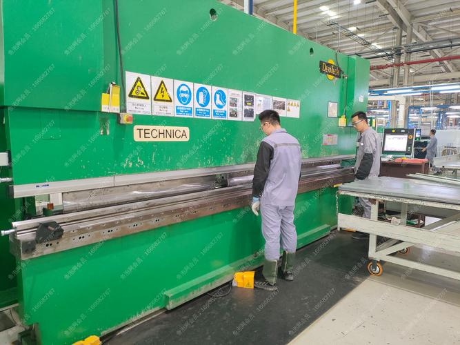折弯机操作工正在调整模具间隙进行试折