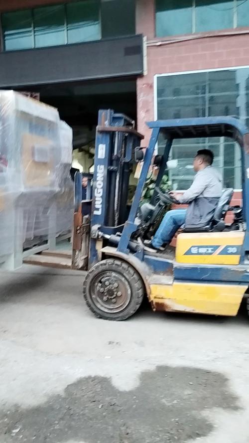老旧柴油叉车在昏暗工厂搬运货物